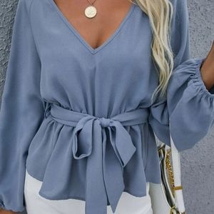Woman's periwinkle blue belted blouse